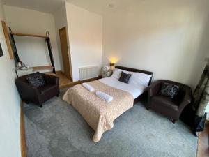 a bedroom with a bed and two chairs at OYO The Old Mill in Yarm