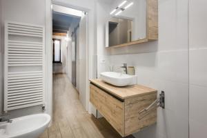 a white bathroom with a sink and a mirror at Flats4Rent Irene in Verona