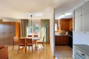 a kitchen and dining room with a table and chairs at Aparthotel Helvetia in Crans-Montana