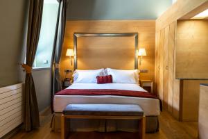a hotel room with a bed and a dresser at Gran Hotel – Balneario de Panticosa in Panticosa