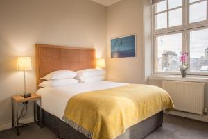 a bedroom with a large bed and a window at PREMIER SUITES PLUS Glasgow George Square in Glasgow