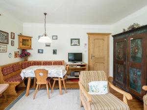 a living room with a table and chairs and a tv at Charming Apartment in Kitzbuhel with Balcony in Kitzbühel