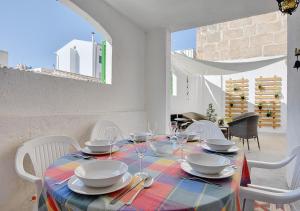 a table with white chairs and a colorful table cloth at Alvaro Oliver House by Slow Villas in Porto Cristo