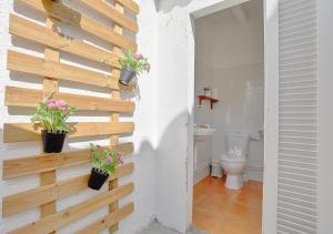 a bathroom with a toilet and two potted plants on a wall at Alvaro Oliver House by Slow Villas in Porto Cristo +24 photos