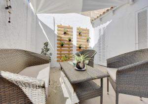 a patio with wicker chairs and a table with plants at Alvaro Oliver House by Slow Villas in Porto Cristo