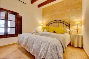 1 dormitorio con 1 cama grande con almohadas amarillas en Villa Can Pujadas by Slow Villas, en Manacor