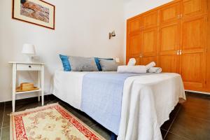 a bedroom with a bed and a wooden cabinet at Amilcar House by Slow Villas in El Arenal
