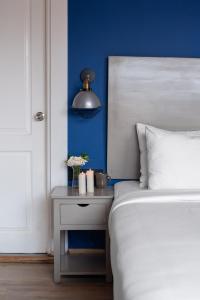 a bedroom with a bed and a side table with a lamp at Living Room Beach Resort in Morjim