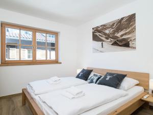 1 dormitorio con 1 cama con sábanas blancas y ventana en Beautiful apartment near the ski area, en Hollersbach im Pinzgau