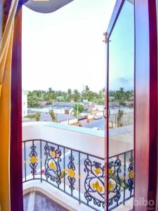 einen Balkon mit einer Tür und Stadtblick in der Unterkunft HOTEL PRISO in Kālapettai