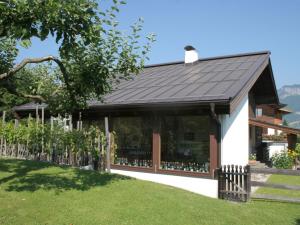uma casa com um telhado preto e um quintal em Apartment in St Johann in Tyrol with a garden em Sankt Johann in Tirol