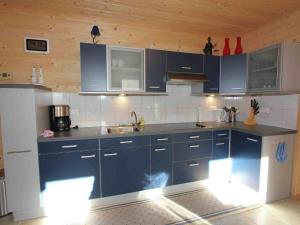 cocina con armarios azules y nevera blanca en Apartment in Umhausen near the ski area, en Umhausen