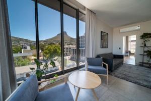 - un salon avec un canapé et une table dans l'établissement Kloof Street Hotel - Lion Roars Hotels & Lodges, au Cap
