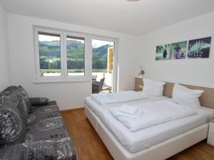 a white bedroom with a bed and a couch at Apartment in ski area in Piesendorf in Piesendorf