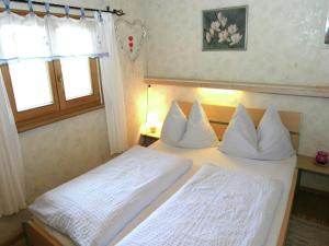 een slaapkamer met 2 bedden met witte lakens en een raam bij Chalet in caroles with a nearby forest in Karrösten