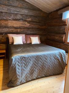 - une chambre avec un lit dans une cabane en rondins dans l'établissement Ruka Chalet Roma, à Ruka