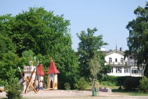 eine Gruppe von Kindern, die auf einem Spielplatz vor einem Haus spielen in der Unterkunft Åhus B&B och Vandrarhem in Åhus