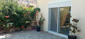 a patio with a sliding glass door and flowers at Marilen in Livadia