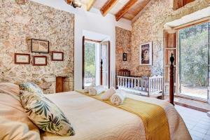 Crestatx的住宿－Villa Aubons by Slow Villas，一间卧室配有一张大床和一张婴儿床。