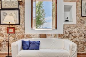 sala de estar con sofá blanco y ventana en Villa Aubons by Slow Villas, en Crestatx