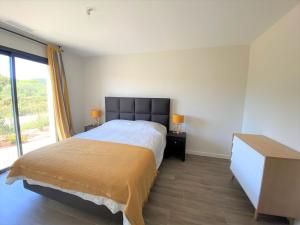 een slaapkamer met een bed, een dressoir en een raam bij Villa Lauredana in Sainte-Lucie de Porto-Vecchio