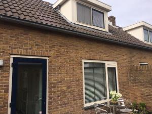 a brick house with a window and a table at Zomerhuis Zuid 1 in Egmond aan Zee