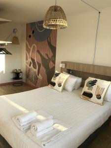 een slaapkamer met een bed met handdoeken erop bij Hôtel Heod - Binic - Saint-Quay-Portrieux in Étables