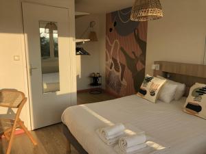 ein Schlafzimmer mit einem Bett mit Handtüchern darauf in der Unterkunft Hôtel Heod - Binic - Saint-Quay-Portrieux in Étables