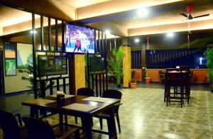 Un restaurante con mesas y sillas y un televisor. en HOTEL SOUTHERN HERITAGE, en Udupi