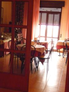 uma sala de jantar com mesas e cadeiras e uma janela em Agathae Hotel & Residence em Scoglitti