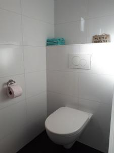 een witte badkamer met een toilet en een handdoek bij Zomerhuis Zuid 1 in Egmond aan Zee