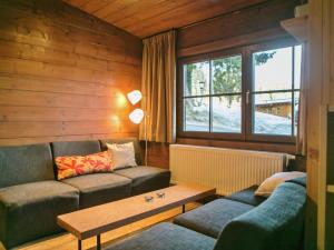 a living room with a couch and a table at Cosy chalet in Tyrol with a private garden in Hopfgarten im Brixental