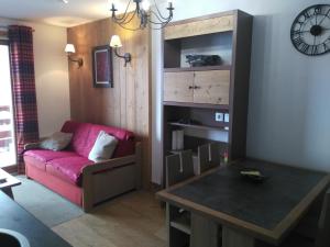 Una sala de estar con un sofá rojo y una mesa. en RISOUL 1850, en Risoul