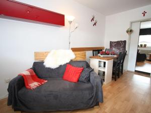 a living room with a grey couch with red pillows at Apartment in Maria Alm directly on the ski slopes in Maria Alm am Steinernen Meer