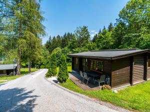 a small cabin with a porch and a road at Cosy chalet in Tyrol with a private garden in Hopfgarten im Brixental