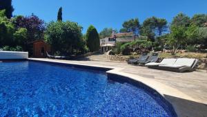 a swimming pool with two lounge chairs next to a house at Gîte Les Grillons in Draguignan