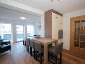 cocina y comedor con mesa de madera y sillas en Apartment in Westendorf Tyrol with terrace, en Westendorf