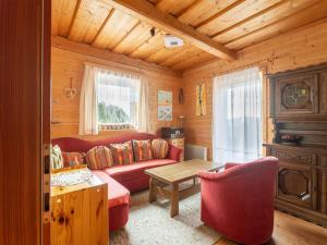 un soggiorno con divano rosso e tavolo di Detached chalet in Reichenau Turracherh he Carinthia near the ski area a Turracher Hohe