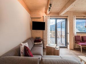 uma sala de estar com um sofá e uma televisão em Chalet in Hohentauern Styria with sauna em Hohentauern