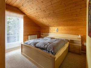 una camera con un letto in una cabina di legno di Detached chalet in Reichenau Turracherh he Carinthia near the ski area a Turracher Hohe