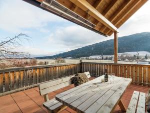 a wooden picnic table on a deck with a view at Chalet in Mauterndorf with sauna in ski area in Mauterndorf