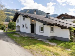 a white house with mountains in the background at Spacious Chalet in Maishofen near Forest in Maishofen