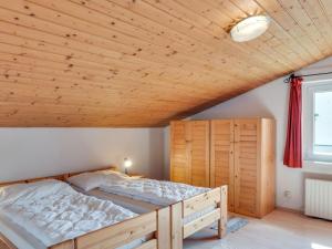 - une chambre avec un lit et un plafond en bois dans l'établissement Spacious Chalet in Maishofen near Forest, à Maishofen