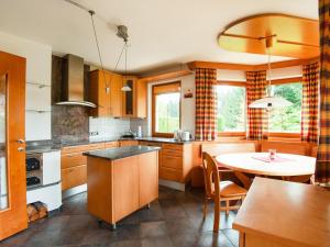 a kitchen with wooden cabinets and a table in it at Holiday house in Reith im Alpbachtal with garden in Reith im Alpbachtal