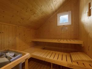 un sauna avec un banc et une fenêtre dans l'établissement Wooden chalet in Hohentauern Styria with sauna, à Hohentauern