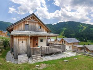 ein Holzhaus mit einer großen Terrasse auf einem Feld in der Unterkunft Wooden chalet in Hohentauern Styria with sauna in Hohentauern