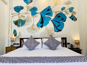 a bedroom with a bed with blue and white pillows at Banburi Villa - 5 Bedroom Private Pool Villa in Krabi town