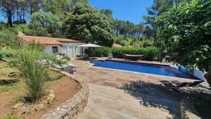 a backyard with a swimming pool and a house at Gîte Les Grillons in Draguignan