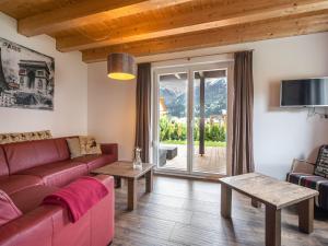 a living room with a red couch and a large window at Chalet in Carinthia near ski area in Kötschach