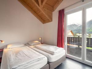 two beds in a room with a large window at Chalet in Koetschach-Mauthen in Carinthia in Kötschach